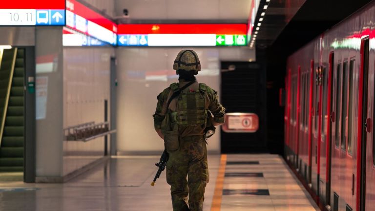 Varusmies kävelee metroasemalla poispäin kamerasta selkä kameran suuntaan.
